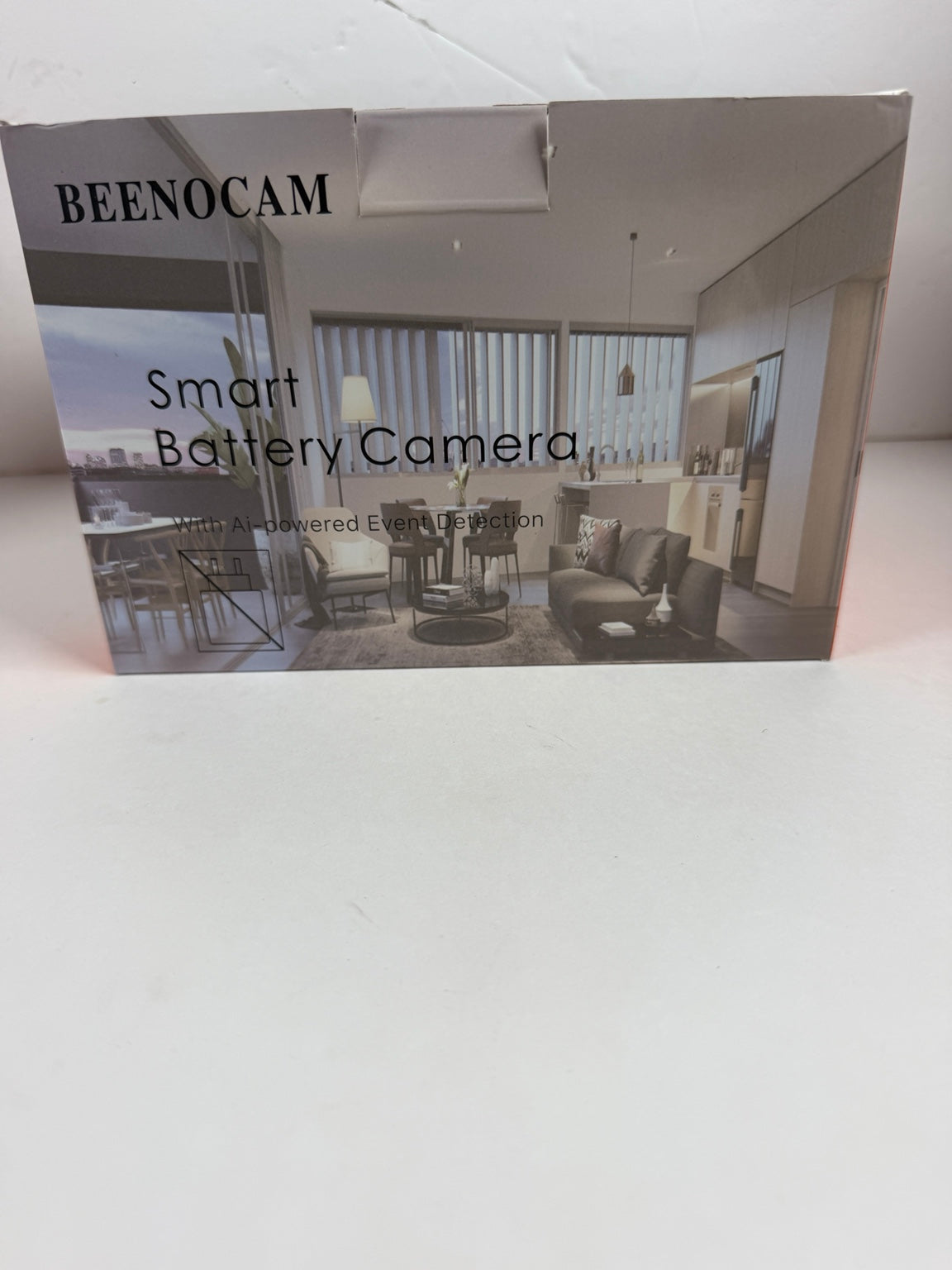 A boxed Beenocam Smart Battery Camera shown on a plain white surface, with the front packaging featuring a modern living room photo and product text.