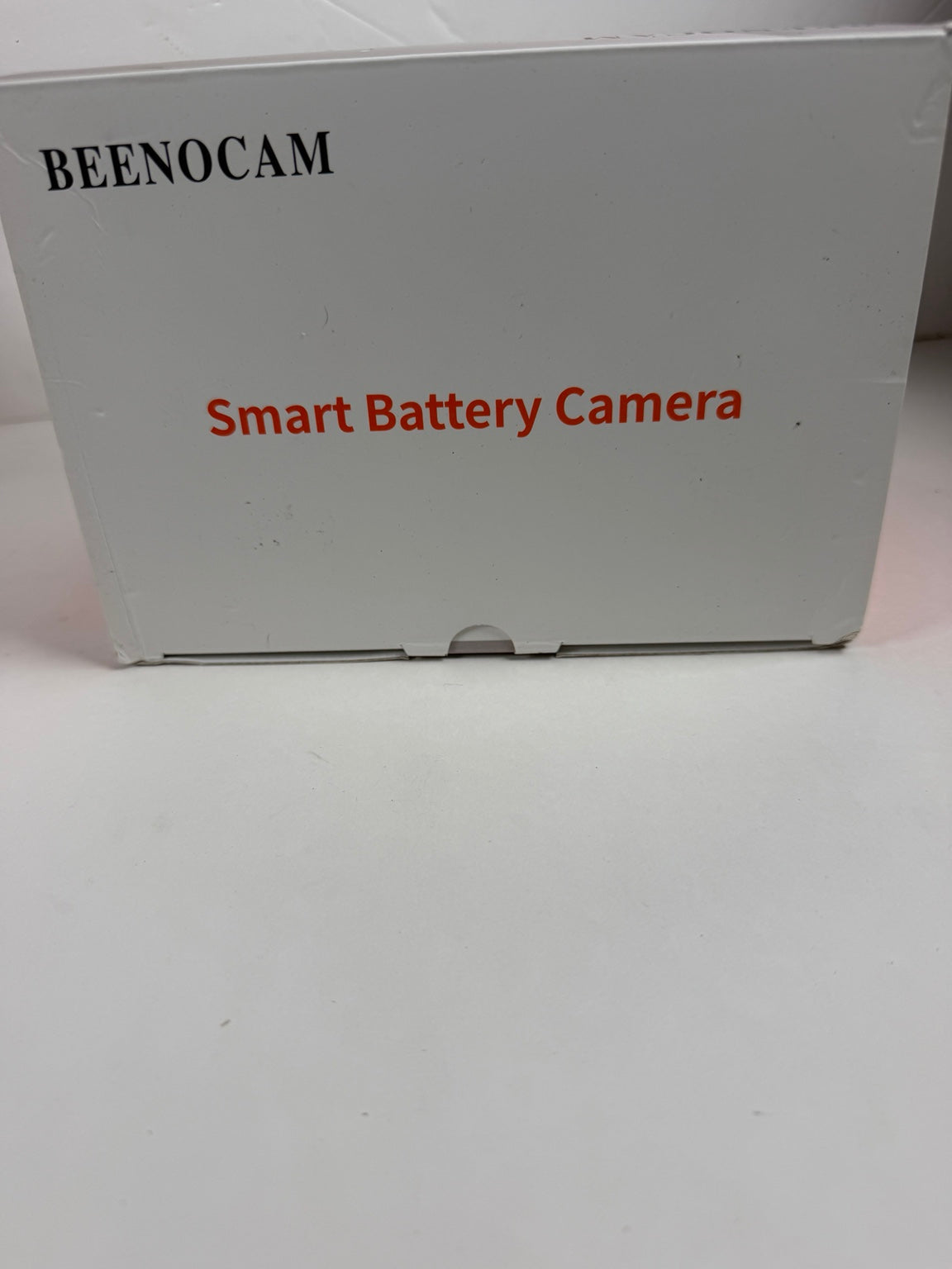 A white product box for a BEENOCAM Smart Battery Camera, with black and red text printed on the front, set against a plain white background.
