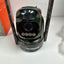 A BEENOCAM wireless security camera with a black and green camouflage pattern, featuring two vertical antennas and a clear face shield, shown on a white surface next to its orange retail box.