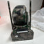 A camouflage-patterned electronic device with two vertical antennas, standing on a matching camouflage base against a white background.