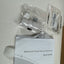 A Network Fixed Dome Cameras Quick Guide booklet with its clear plastic packaging accessories, including a white mounting bracket and screws, laid out on a light surface.