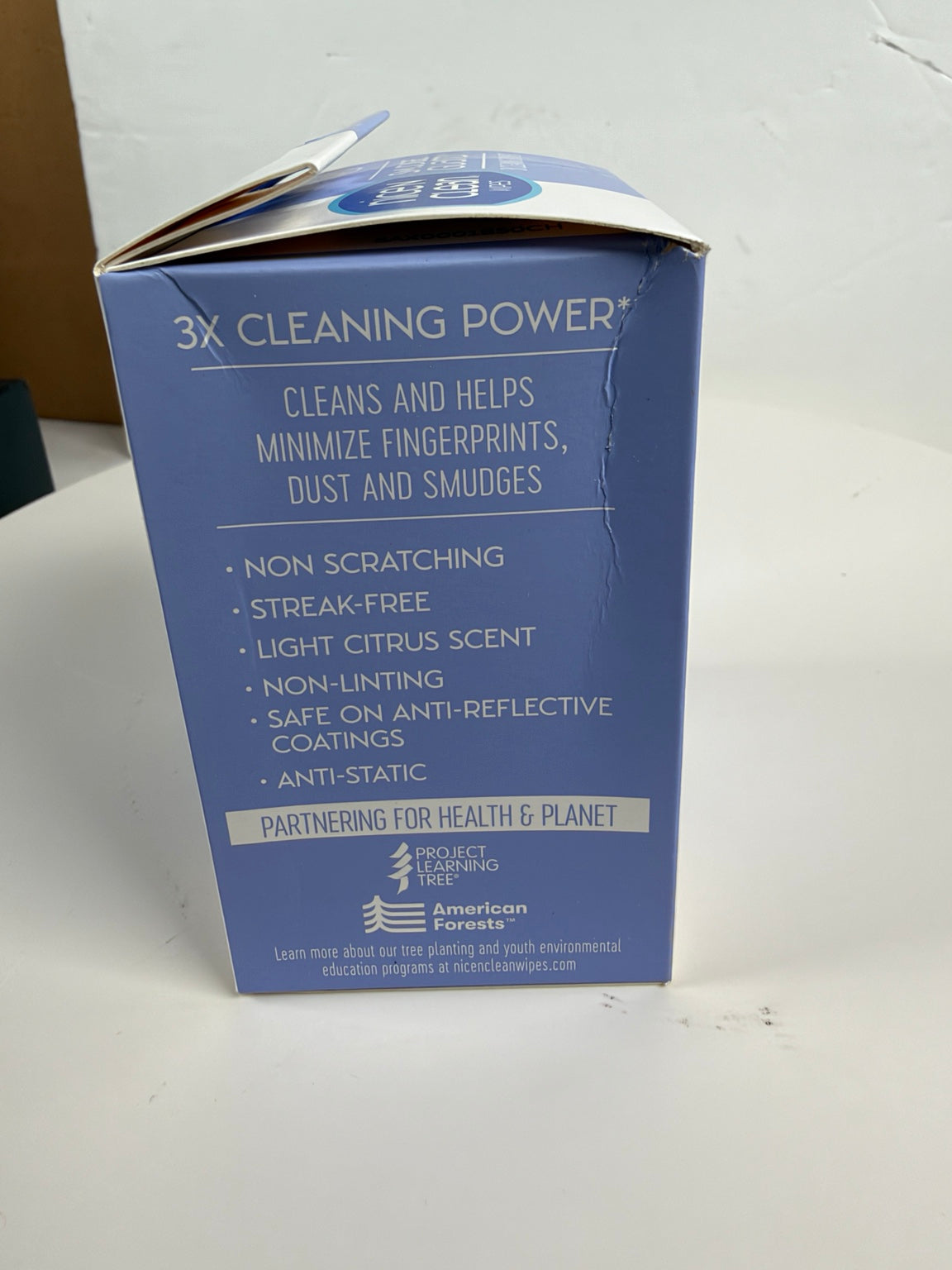 A blue box of American Forests 3X Cleaning Power cleaner, showing product details and benefits on a white surface.