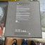 The back of a Samsung Galaxy Z Fold 7 product box, showing printed specifications and icons on a dark gray surface, photographed on a desk with a person's feet visible at the bottom.
