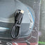A black USB-C to USB-A data and charging cable coiled with a black elastic band, resting on a dark printed surface.