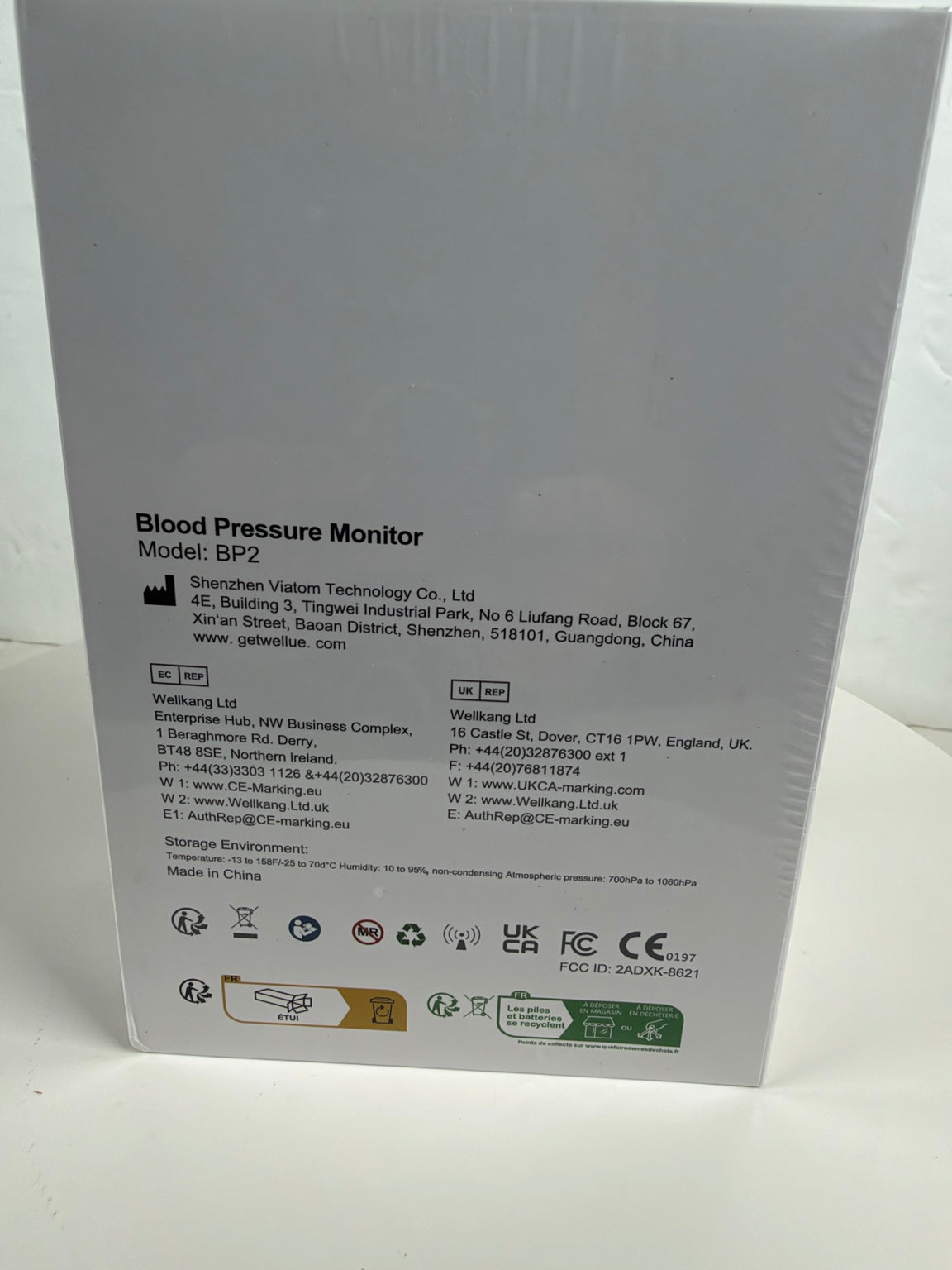 The back of a white Blood Pressure Monitor box, showing product details, model BP-2, manufacturer information, and various certification logos.