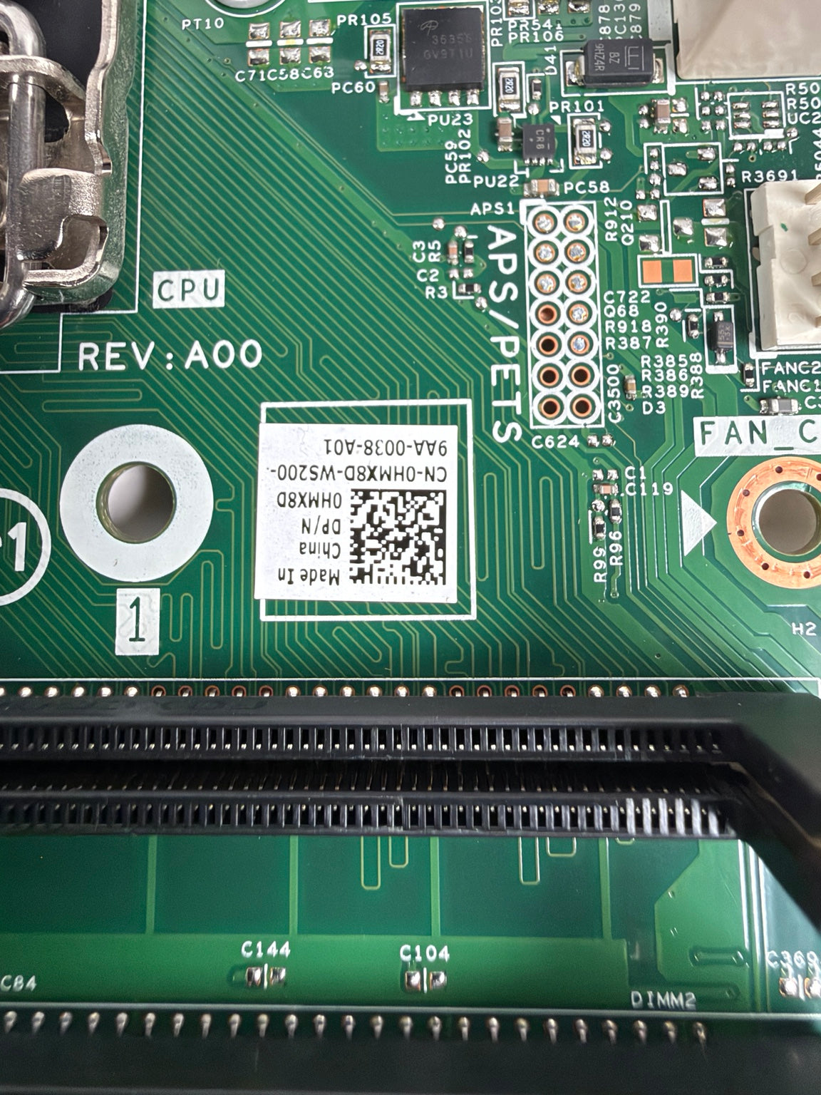 Close-up of a green printed circuit board with visible components, a white QR code label, and printed text including CPU, REV:A00, APS-PETS, and FAN.
