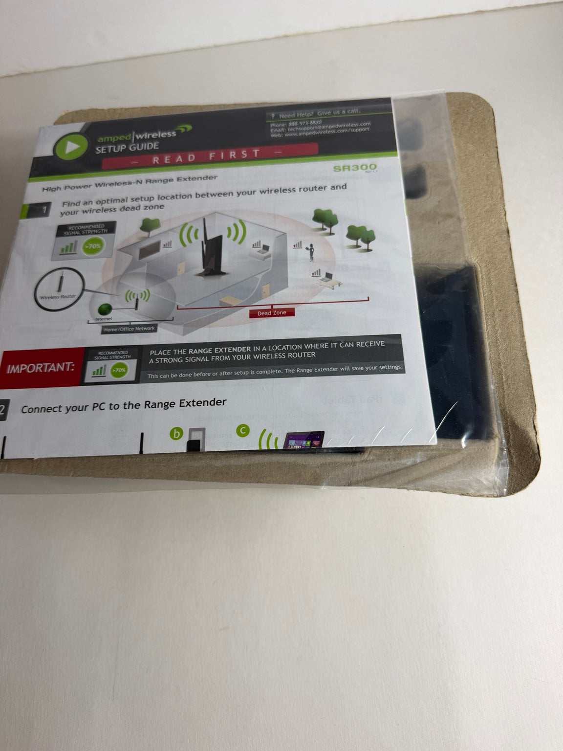 A packaged wireless range extender setup guide booklet, model BR300, sealed in clear plastic on a light-colored surface.