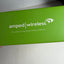 A close-up of a bright green Amped Wireless product box with white printed branding and the tagline 'The Leader in High Power Wireless Solutions' on a light surface.