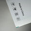 A close-up of a white corrugated cardboard box corner with printed black handling icons and the text 'Made in China' on a gray surface.