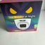 A boxed security camera product on a light gray surface. The box is mostly dark with a colorful gradient, yellow eye graphics, and a printed image of a white dome camera.