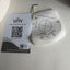 UNV network eyeball camera mounting hardware and documentation card on a light gray surface. The image shows a white circular mounting template with a metal screwdriver bit, a small hex key, and a printed UNV document card with a QR code.