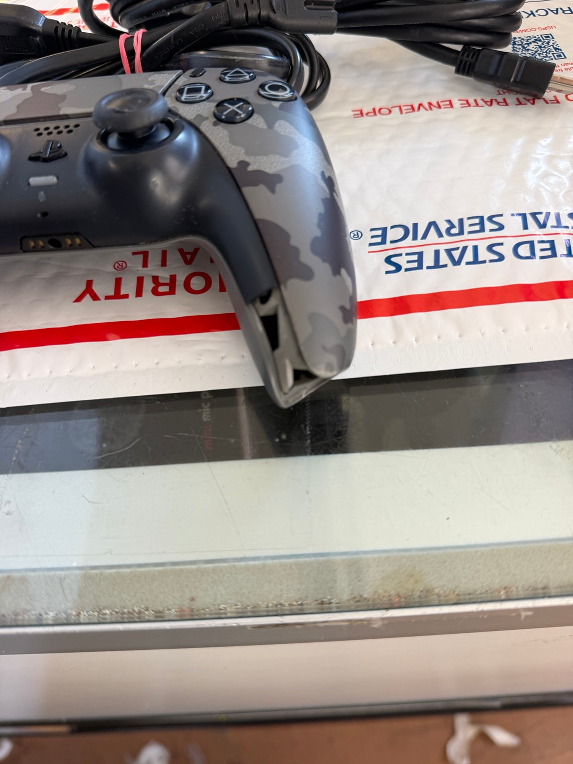 Close-up of Sony PS5 camouflage DualSense controller showing analog sticks and cosmetic wear